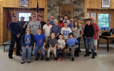 Volunteers at Camp Gorton pose for a group picture in front of the dining hall fireplace
