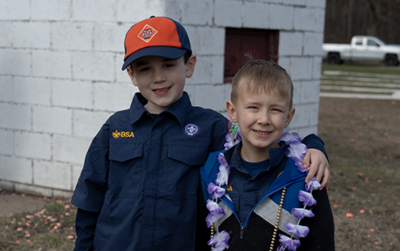 Two Cub Scouts in uniform standing side by side smiling. Photo by Eli Kester https://www.instagram.com/lunarflaremedia/