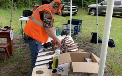 A volunteer prepares 22-caliber rifles for Scouts to practice target shooting with